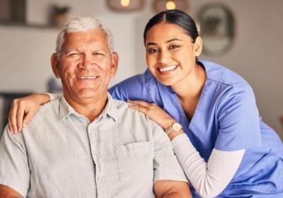 Senior male patient and compassionate nurse smiling for photo