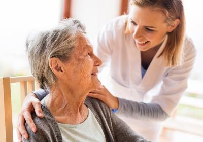 Health care provider warmly interacting with senior female patient